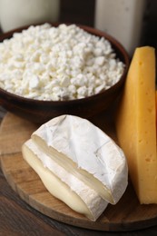 Photo of Dairy products. Different kinds of cheese on wooden table, closeup