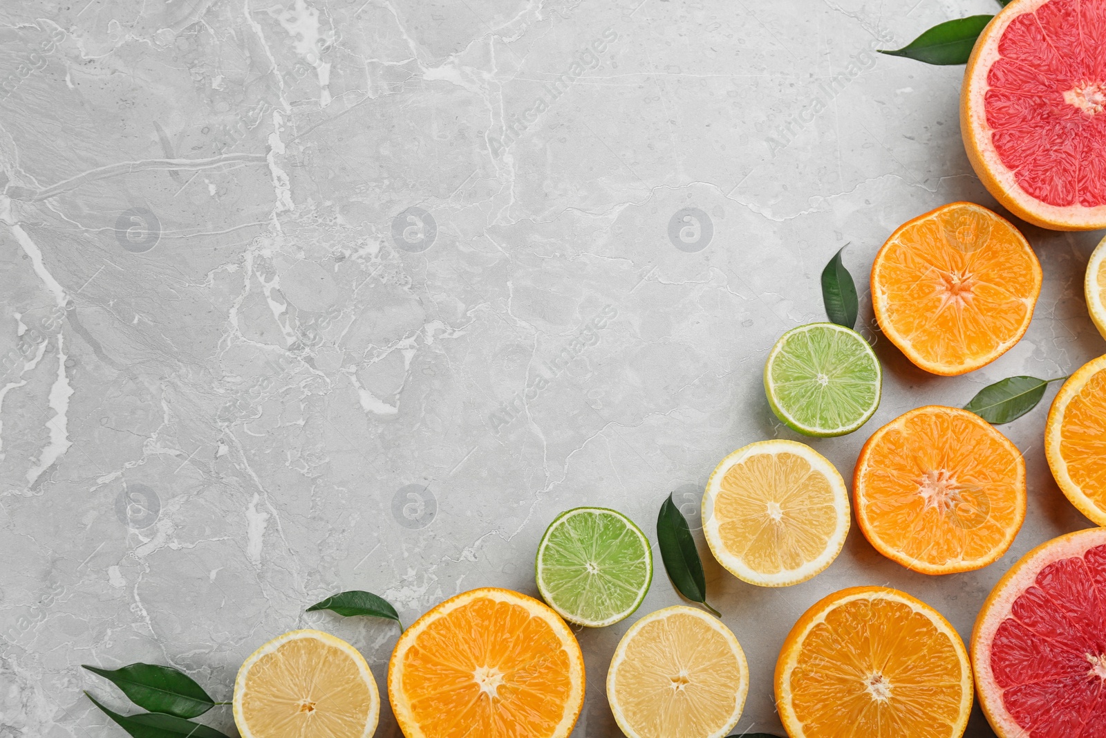 Photo of Flat lay composition with tangerines and different citrus fruits on grey marble background. Space for text