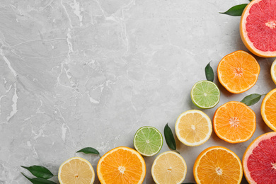 Flat lay composition with tangerines and different citrus fruits on grey marble background. Space for text