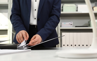 Woman working with documents at table in office, closeup