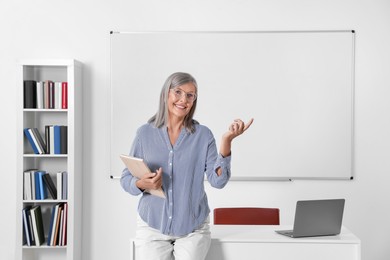 Photo of Portrait of happy professor near whiteboard in classroom