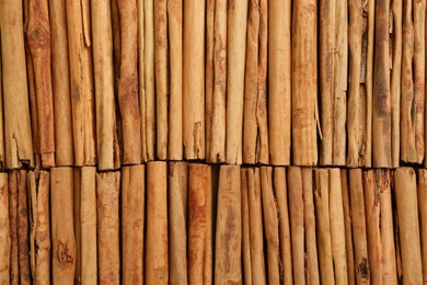 Photo of Aromatic cinnamon sticks as background, top view