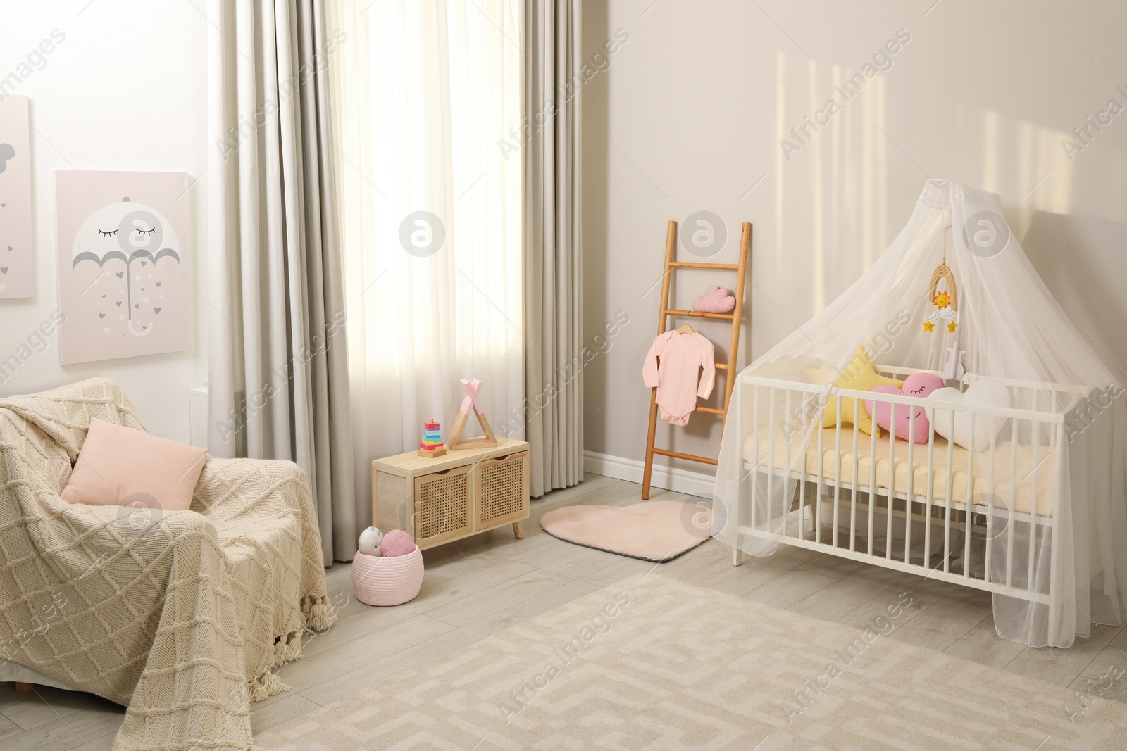 Photo of Cozy baby room with crib and other furniture. Interior design