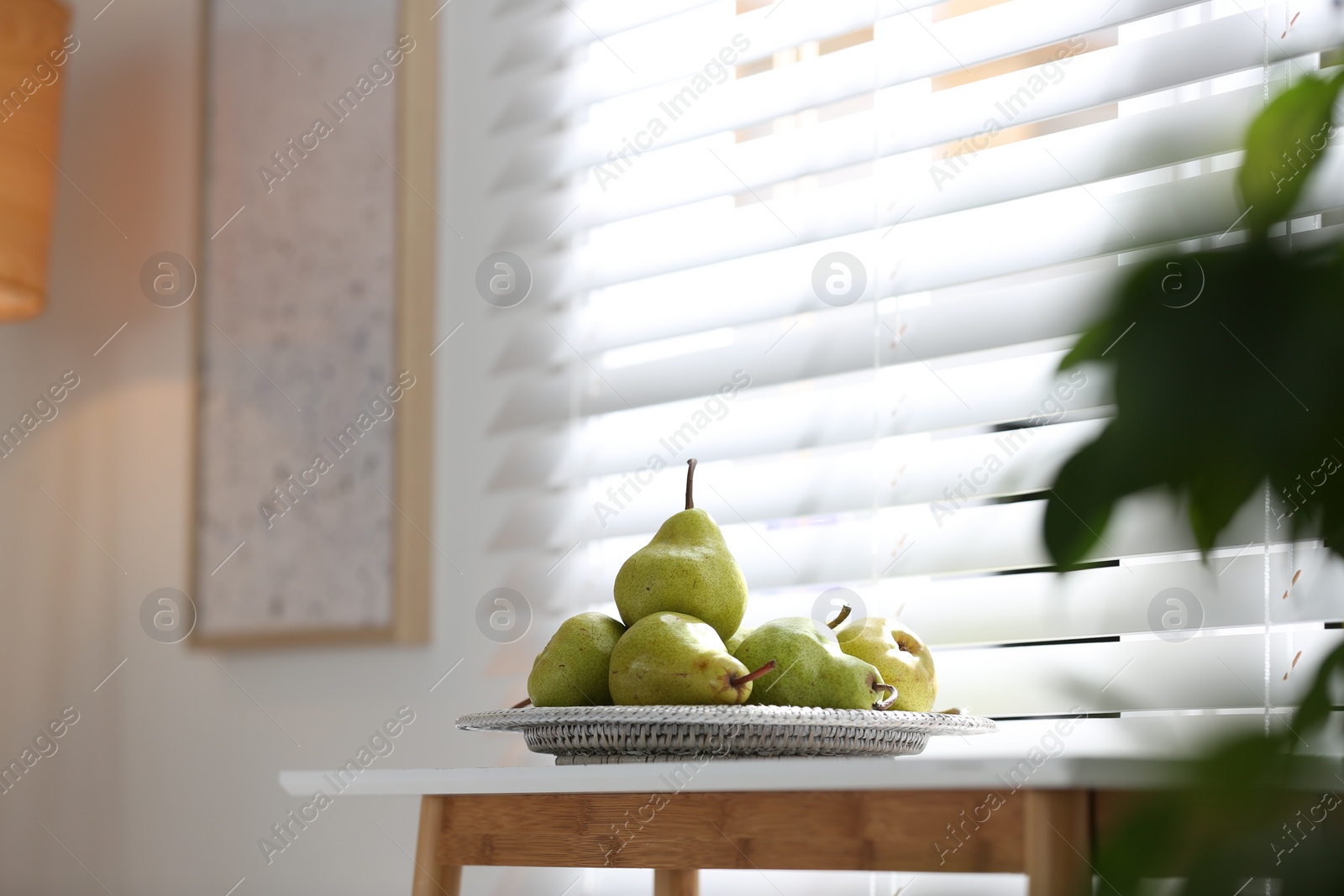 Photo of Fresh ripe pears on white table in room