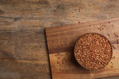 Photo of Buckwheat grains on wooden table, top view. Space for text