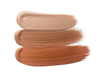 Image of Different shades of liquid foundation on white background, top view