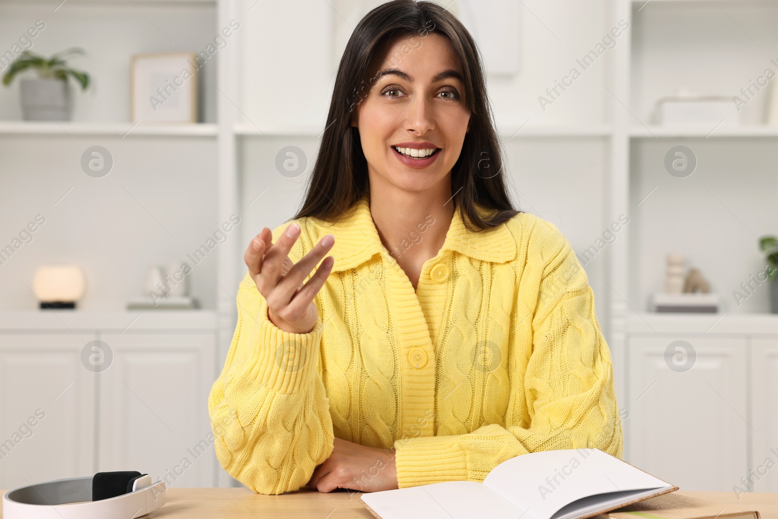 Photo of Happy woman sitting at table in room