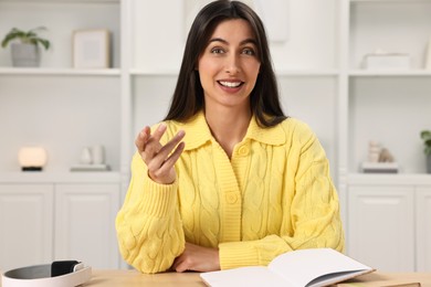 Happy woman sitting at table in room