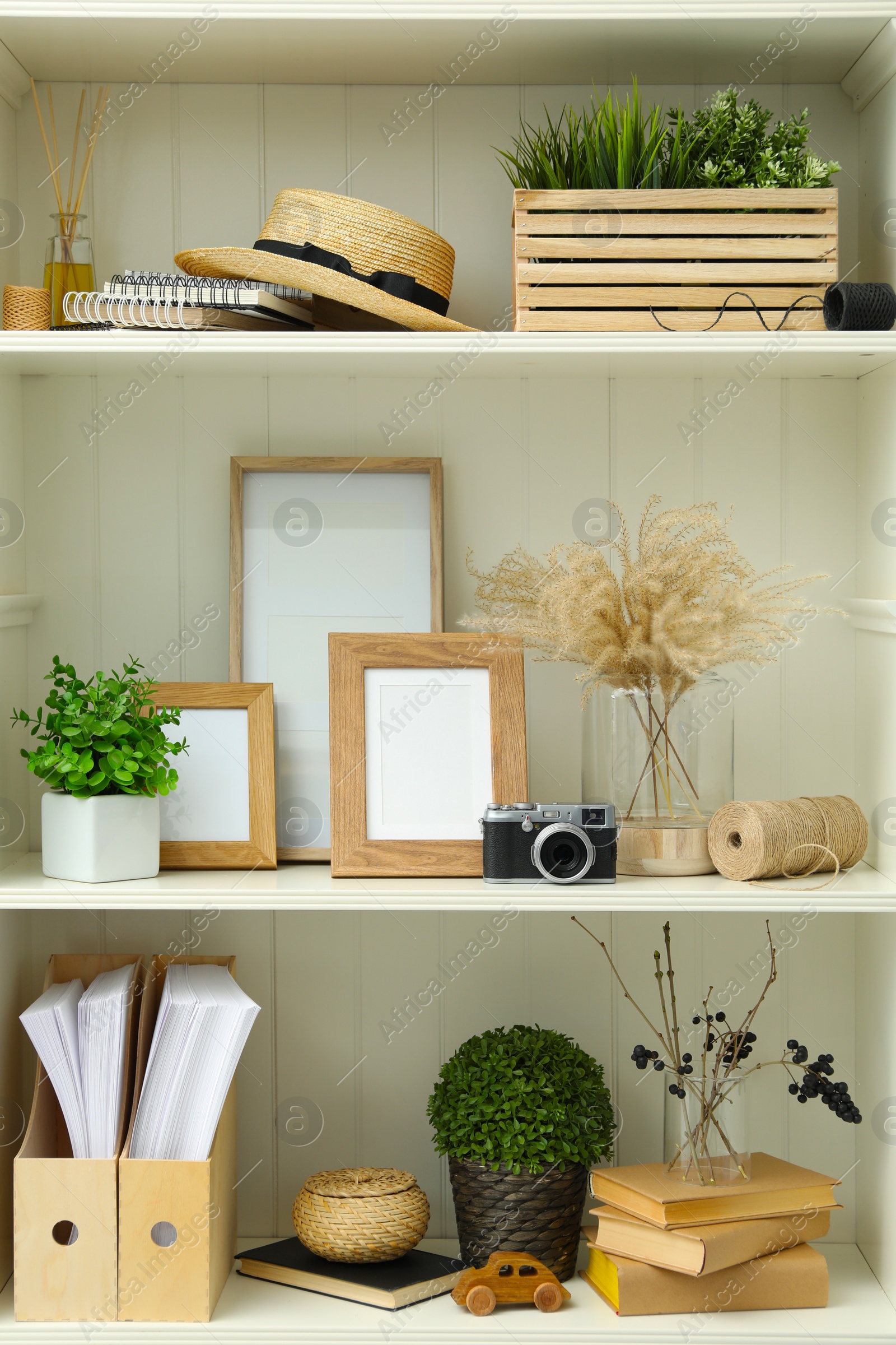 Photo of White shelving unit with different decorative elements