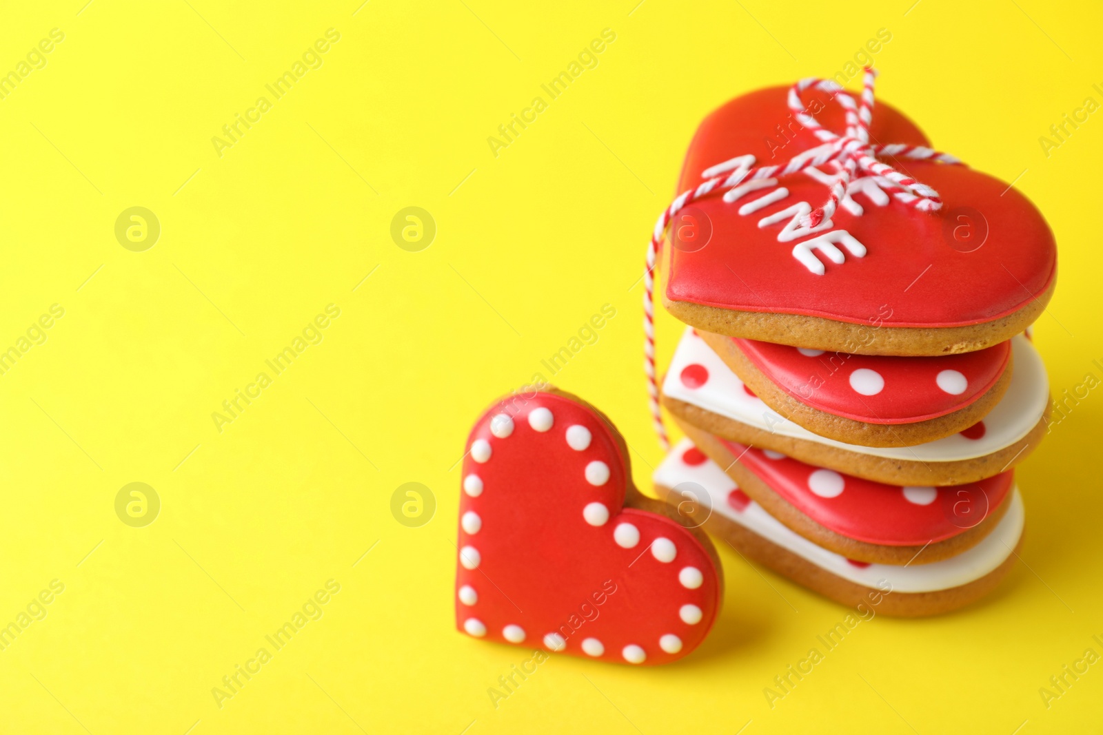 Photo of Gift set of heart shaped cookies on yellow background, closeup with space for text. Valentine's day treat