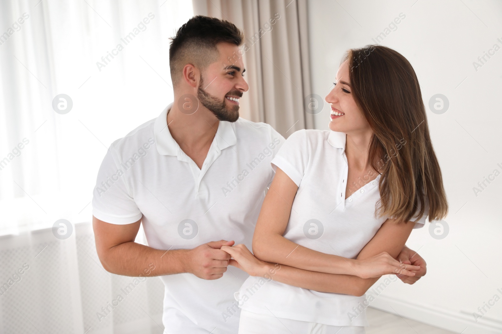 Photo of Lovely young couple dancing together at home