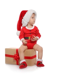 Cute little baby in Christmas costume and gift on white background