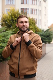 Handsome man wearing stylish clothes on city street. Autumn walk