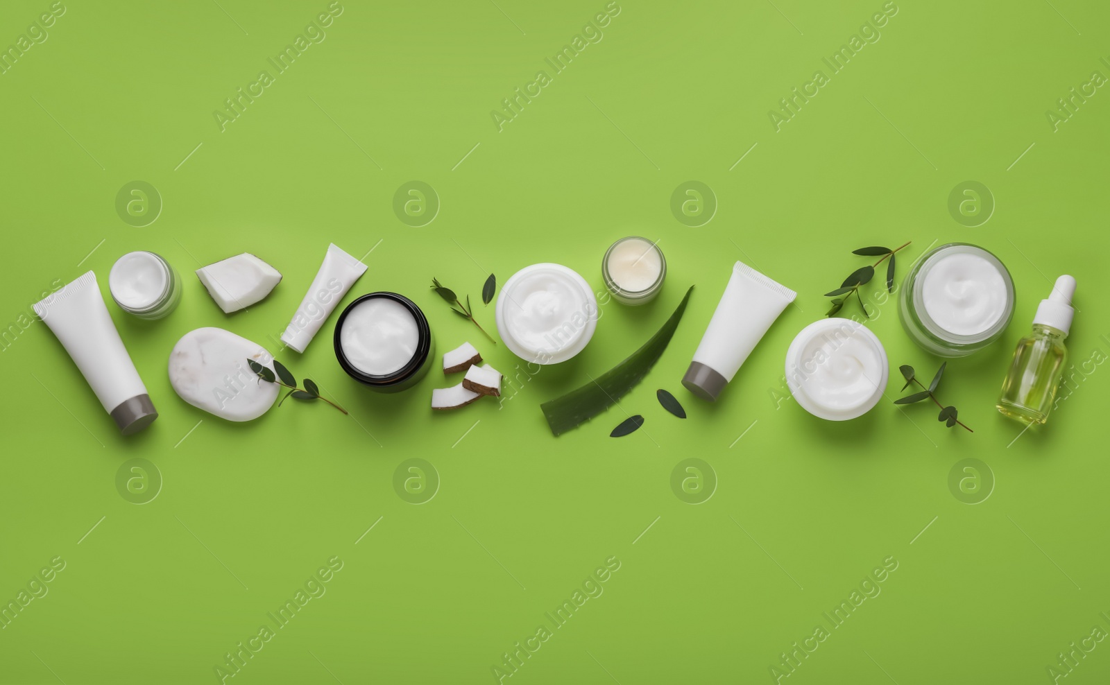 Photo of Body cream and other cosmetic products with ingredients on light green background, flat lay