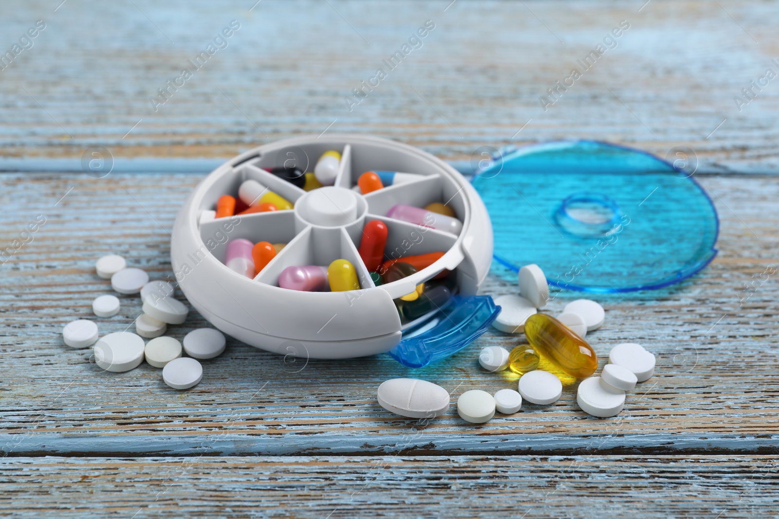 Photo of Pill box with medicaments on wooden table