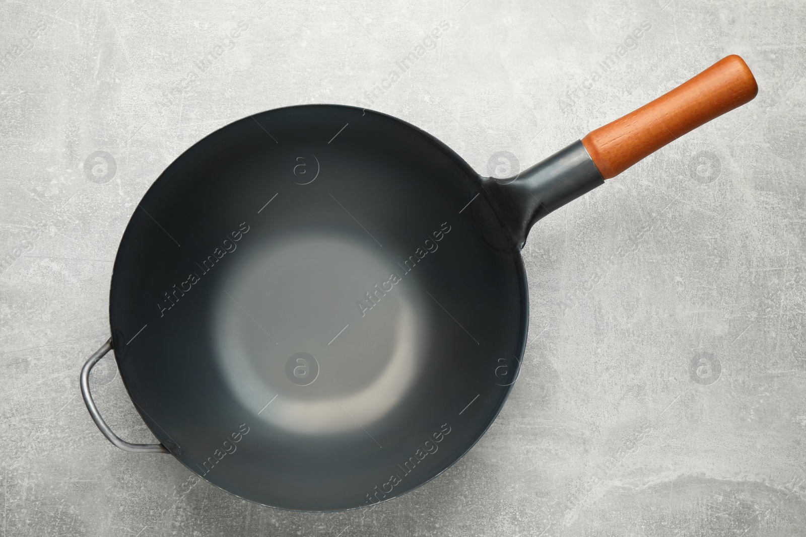 Photo of Empty iron wok on grey table, top view. Chinese cookware