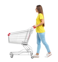 Photo of Young woman with empty shopping cart on white background