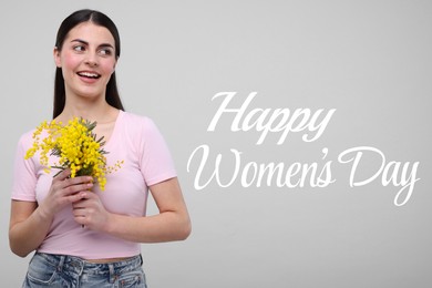 Happy Women's Day - March 8. Attractive lady with mimosa flowers on light grey background