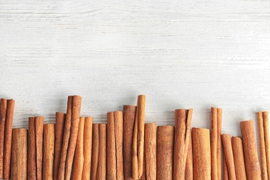 Photo of Aromatic cinnamon sticks on wooden background