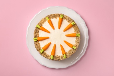 Photo of Dish with tasty carrot cake on pink background, top view