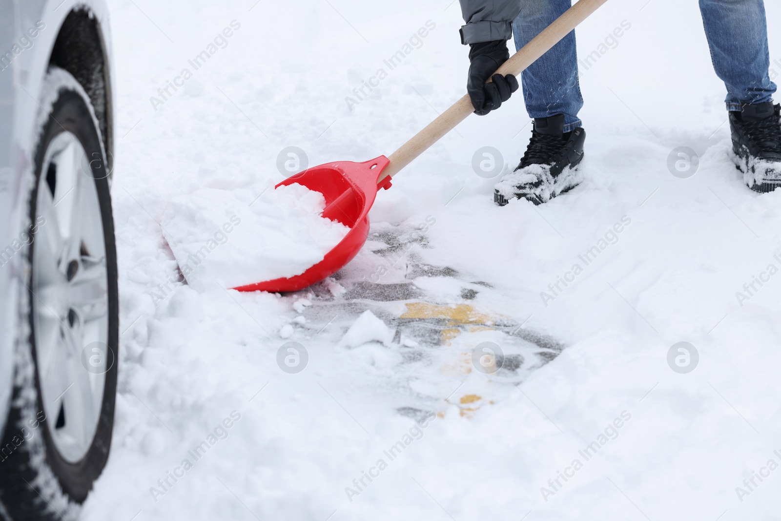 Photo of Man removing snow with shovel near car outdoors, closeup