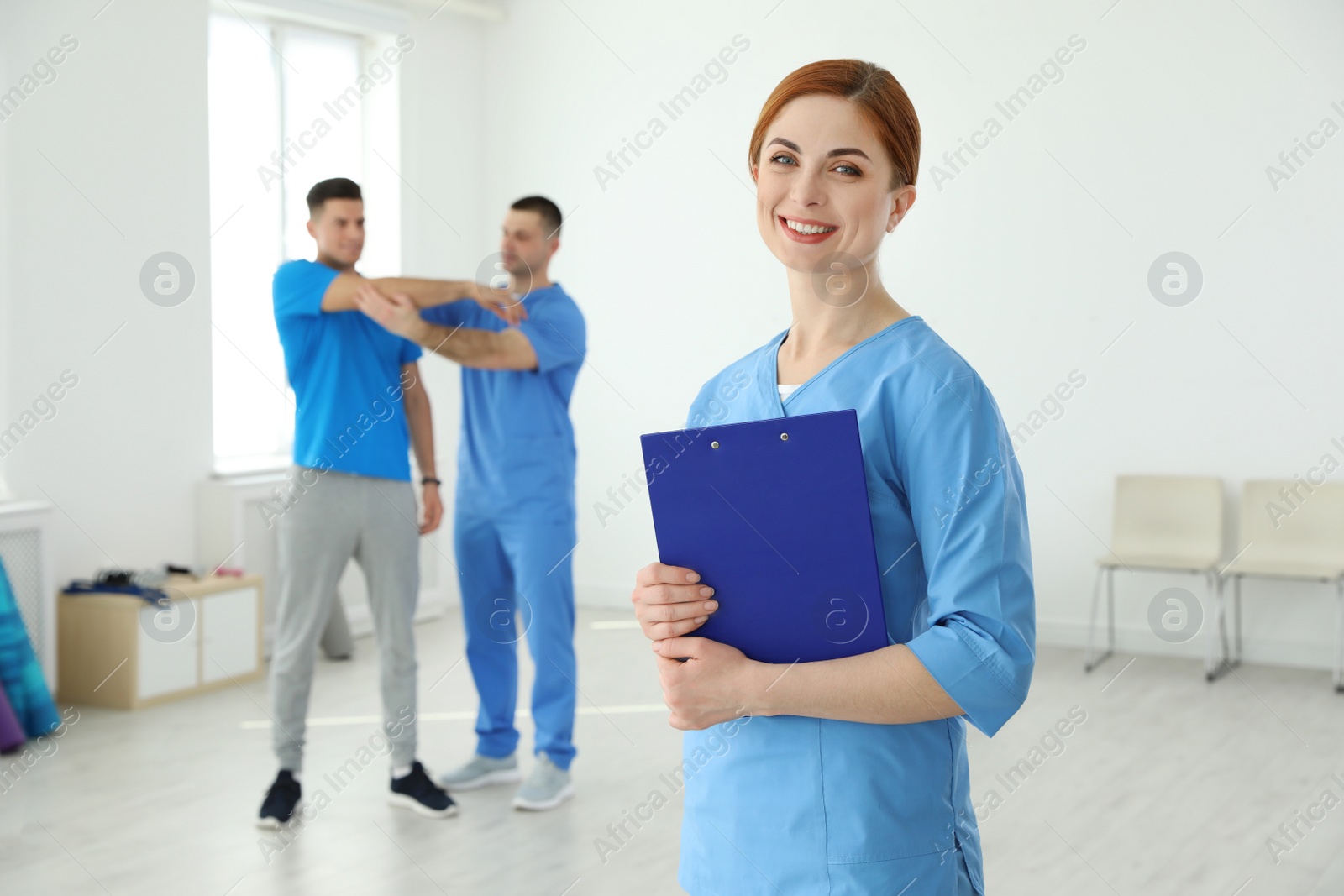 Photo of Portrait of professional physiotherapist with clipboard in rehabilitation center. Space for text