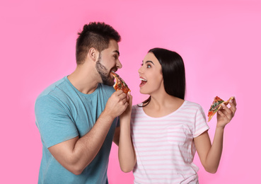 Photo of Emotional couple with pizza on pink background