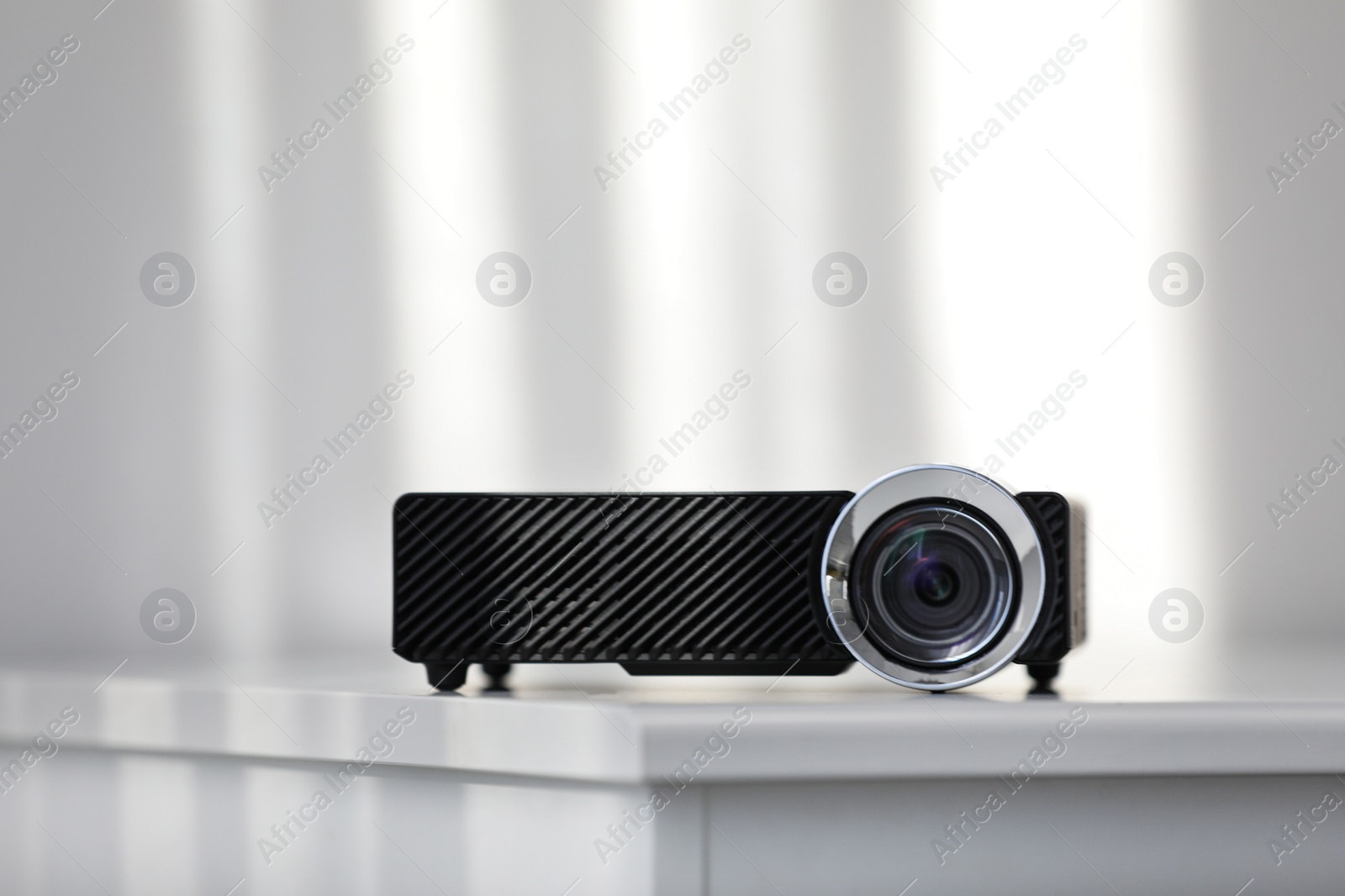 Photo of Modern video projector on white table indoors