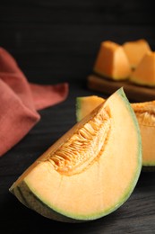 Photo of Tasty fresh cut melon on black wooden table, closeup