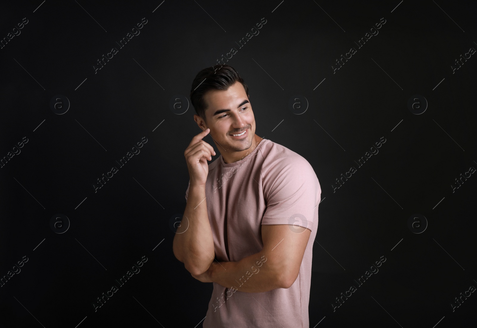 Photo of Portrait of handsome young man on black background