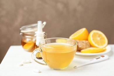 Photo of Cup with hot tea for cold on table