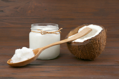 Photo of Composition with organic coconut oil on wooden table. Healthy cooking