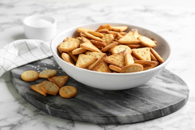 Photo of Delicious crispy crackers on white marble table