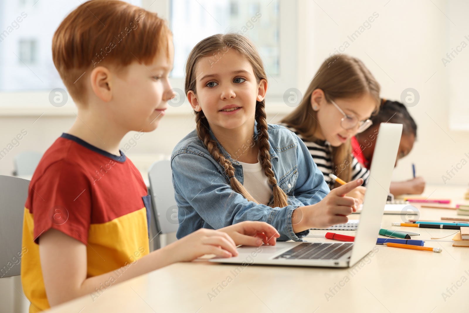 Photo of Cute children studying in classroom at school
