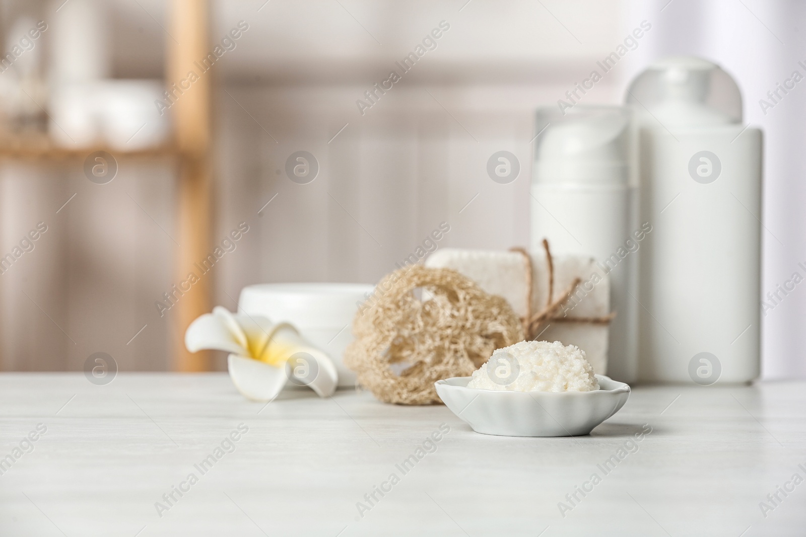 Photo of Bowl with Shea butter and other cosmetic products on table in bathroom. Space for text