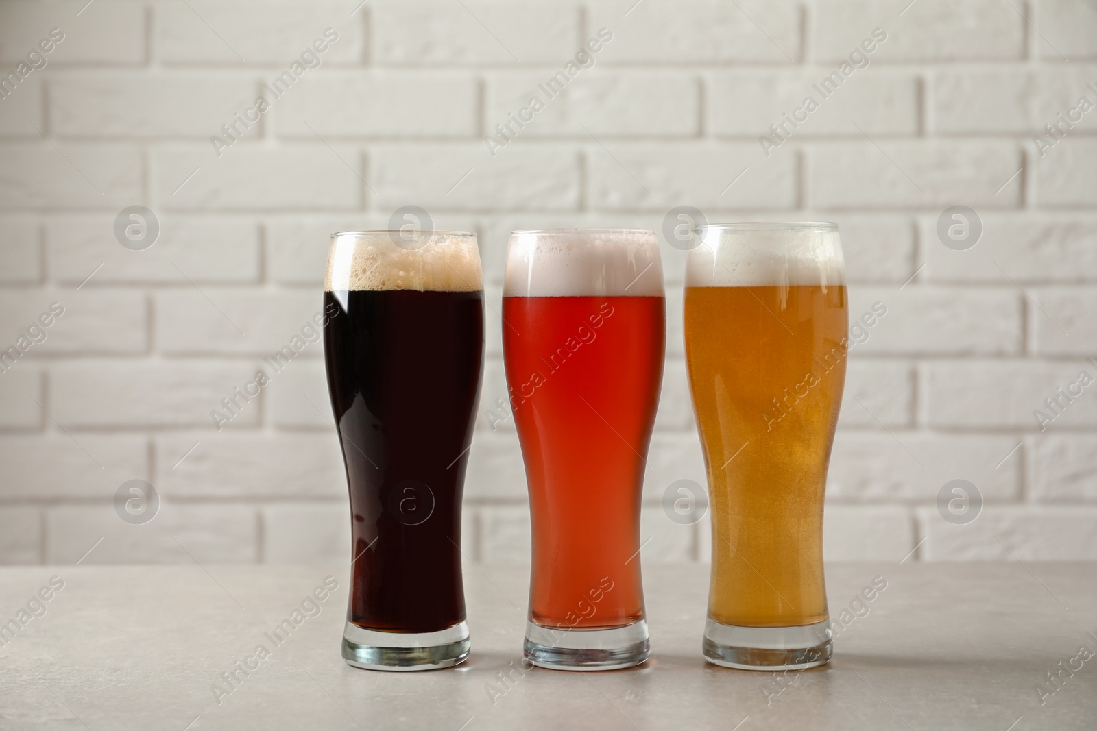 Photo of Glasses with different types of cold tasty beer on table