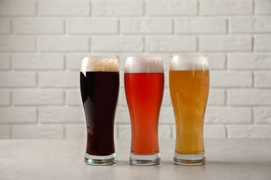 Photo of Glasses with different types of cold tasty beer on table