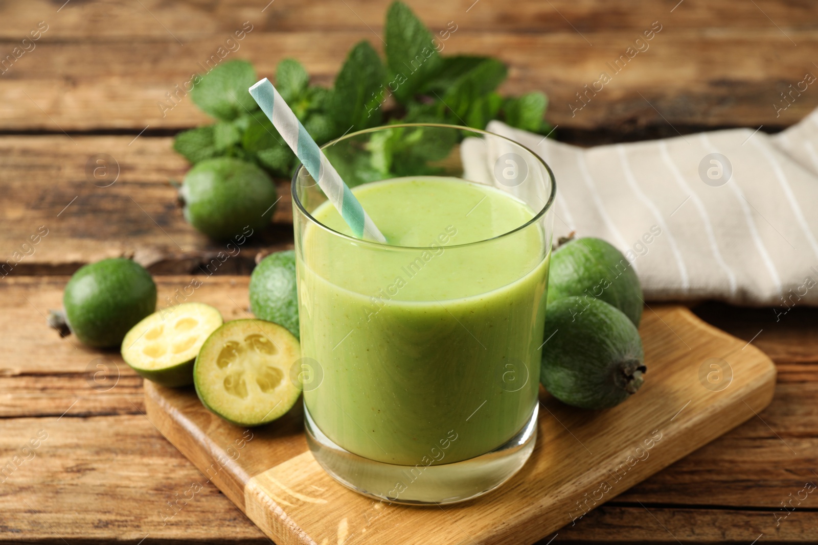 Photo of Fresh feijoa smoothie and fresh fruits on wooden table, closeup