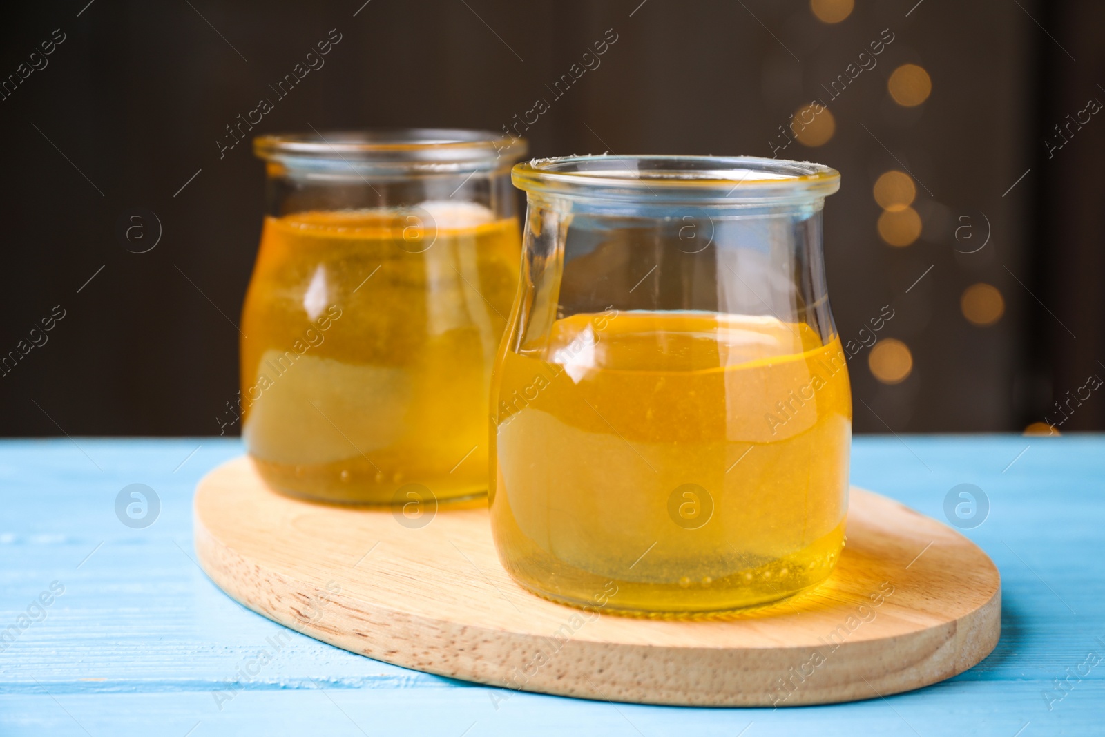 Photo of Tasty aromatic honey on light blue wooden table