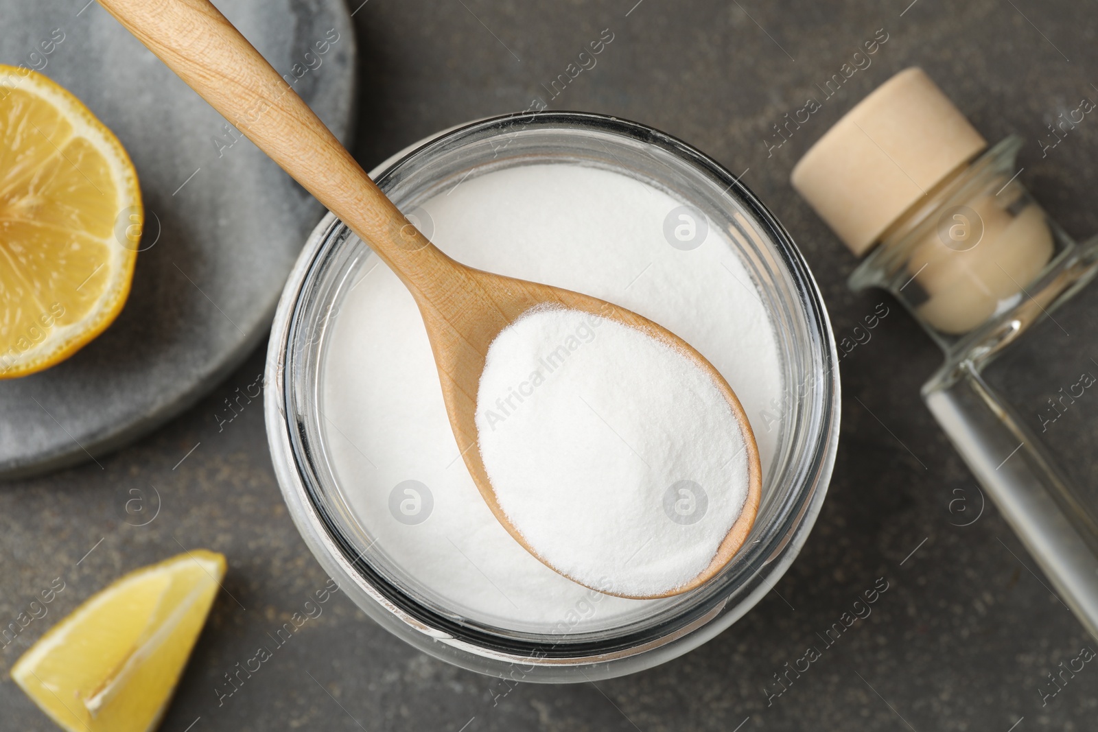 Photo of Baking soda, vinegar and lemon on grey table, flat lay