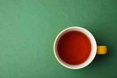 Photo of Cup of black tea on color background, top view