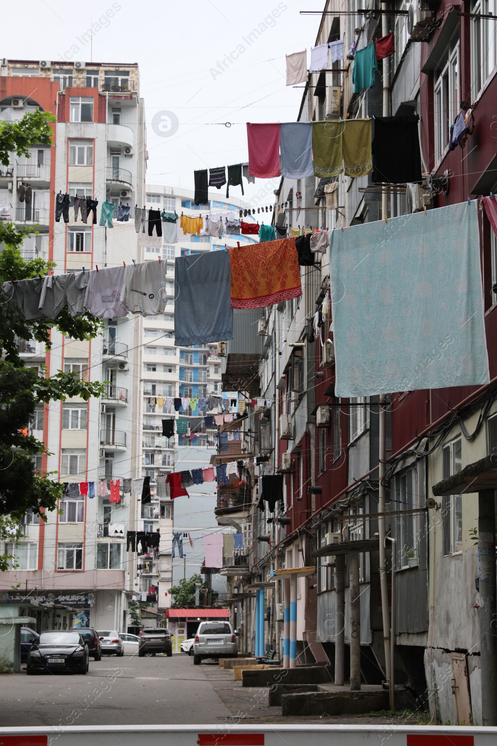 Photo of Washing lines with clean clothes hanging on city street