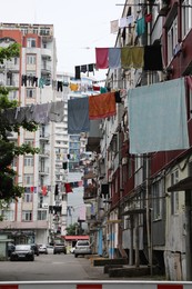 Washing lines with clean clothes hanging on city street