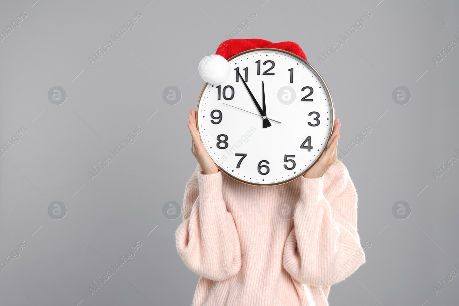 Photo of Woman with clock on grey background. New Year countdown