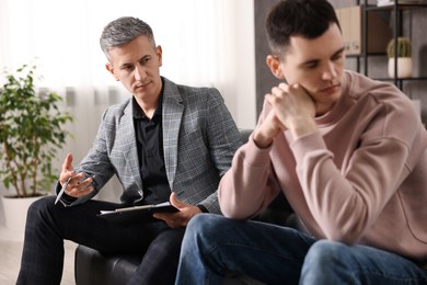 Photo of Professional psychotherapist working with patient in office