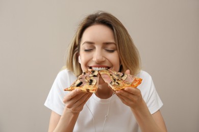 Food blogger eating pizza against beige background. Mukbang vlog