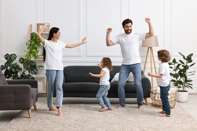 Photo of Happy family dancing and having fun in living room