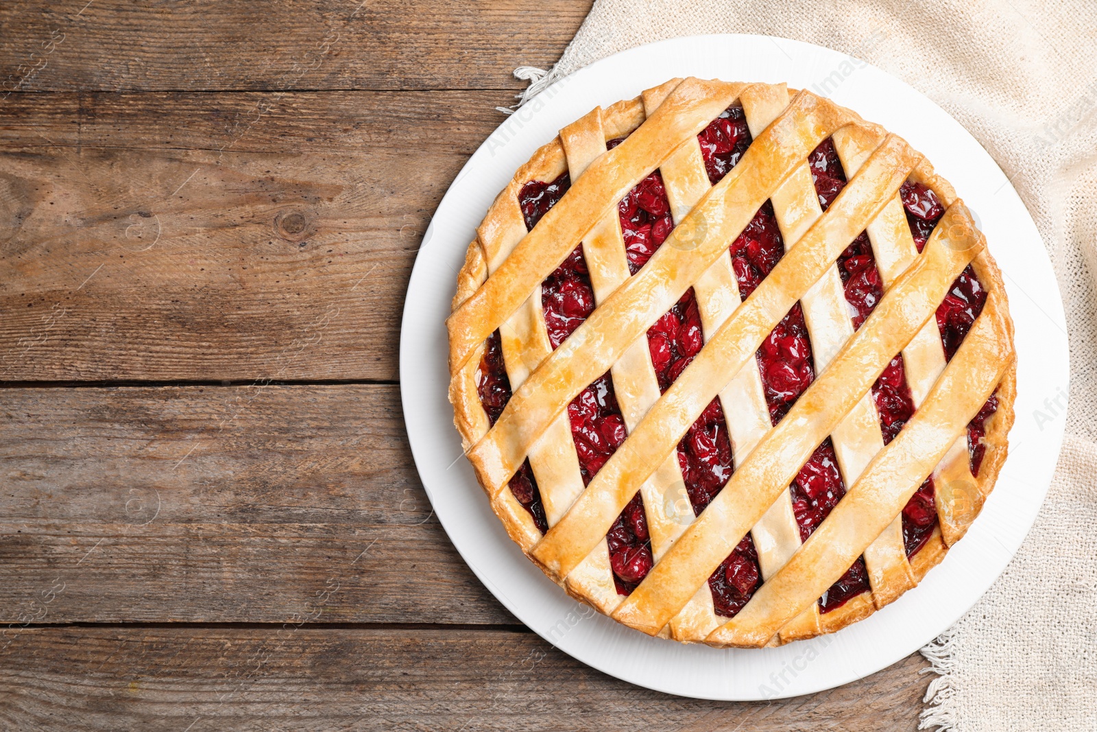 Photo of Delicious fresh cherry pie on wooden table, top view. Space for text