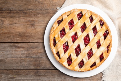 Delicious fresh cherry pie on wooden table, top view. Space for text