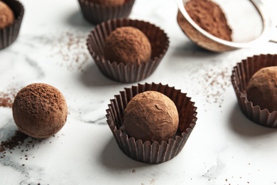 Tasty raw chocolate truffles on marble background